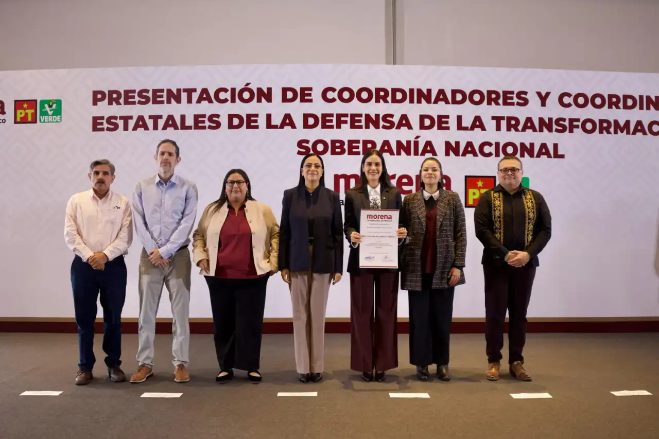 Rosi Bayardo sostiene un nombramiento junto a dirigentes de Morena, PT y PVEM durante un acto político.