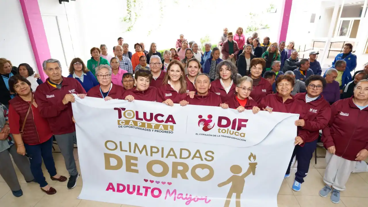 Adultos mayores con medallas y uniformes del DIF Toluca en una ceremonia de premiación
