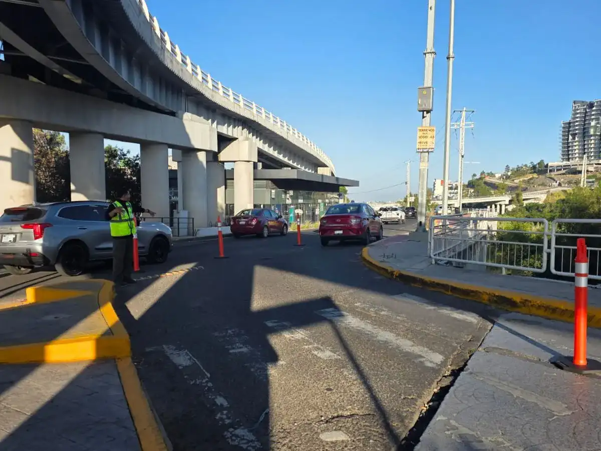 Personal vial y vehículos en un cruce con señalización temporal en Querétaro
