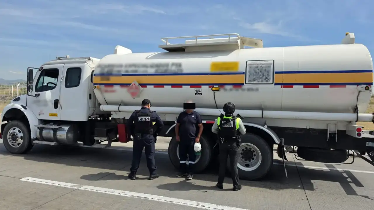 Tractocamión con tanque de combustible detenido en una caseta de cobro