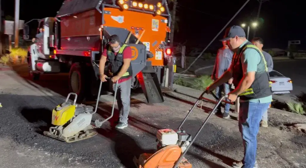 Trabajadores de bacheo nocturno en una vialidad de Cabo San Lucas