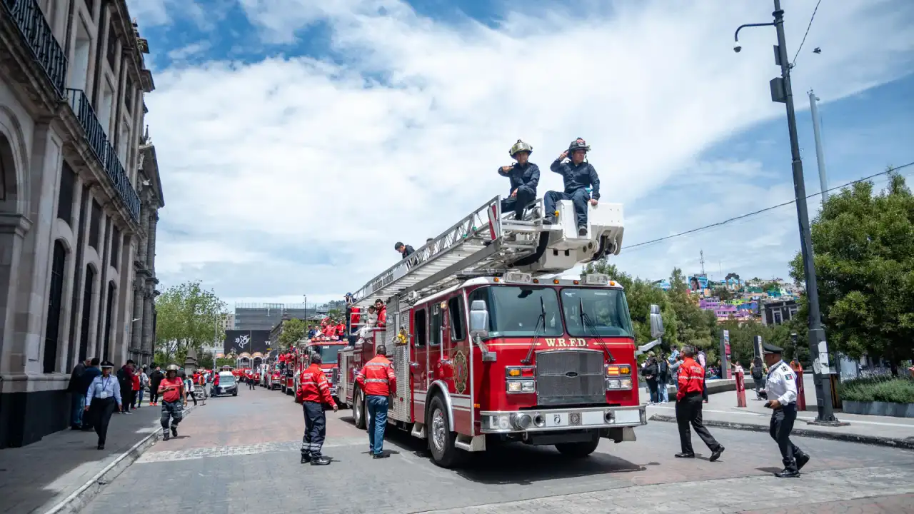 Caravana de bomberos con familias a bordo por calles de Toluca