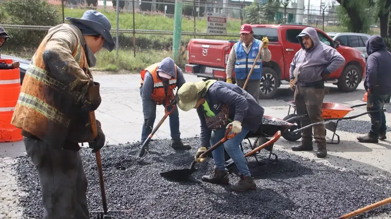 Trabajadores municipales aplican mezcla asfáltica en una calle de Cuautitlán Izcalli
