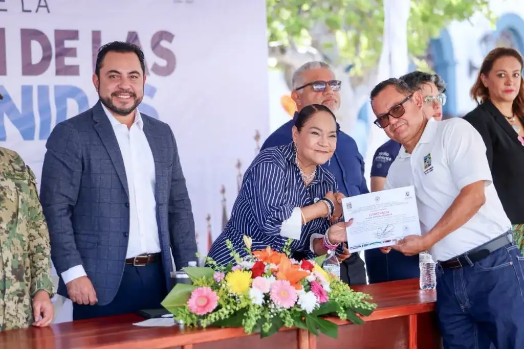 Personas reunidas en un centro comunitario durante una entrega de certificados