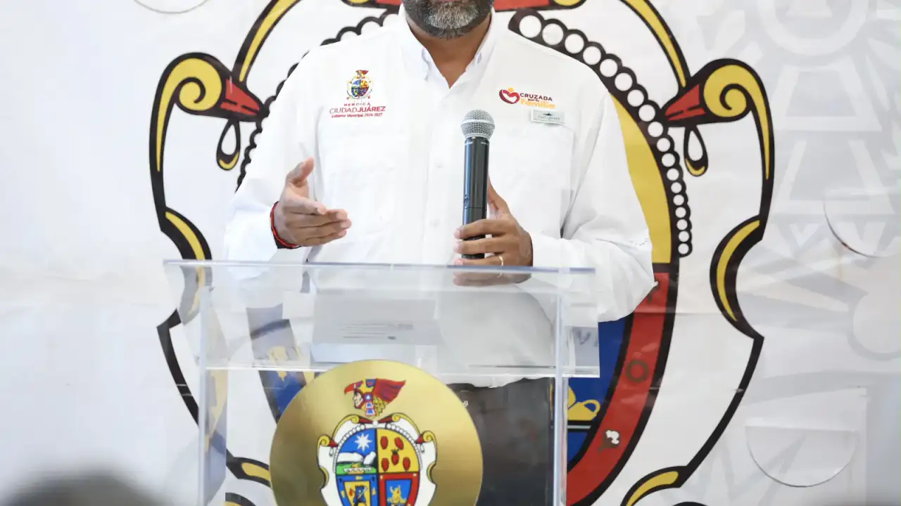 Autoridades municipales entregan cheques simbólicos a jóvenes músicos en biblioteca pública.