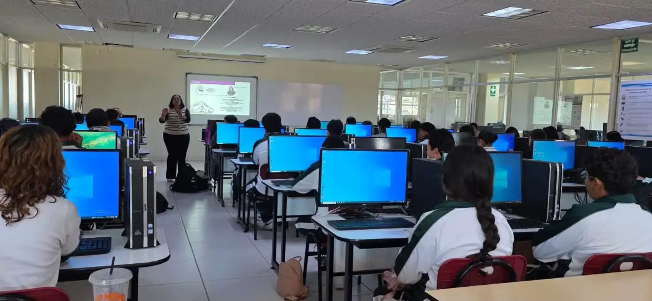 Estudiantes frente a computadoras con sistema operativo Linux en un aula escolar