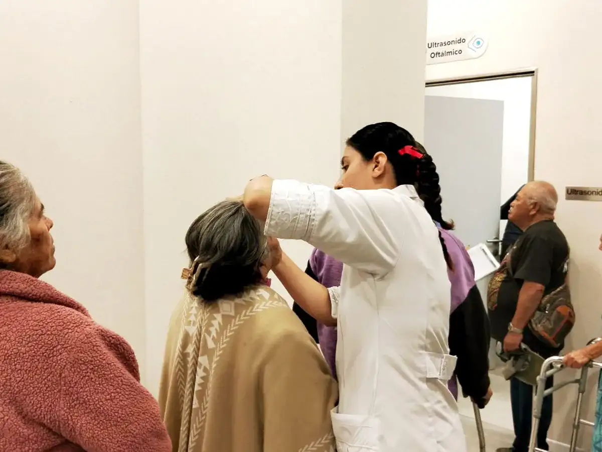 Médico revisando ojos de un paciente en consulta