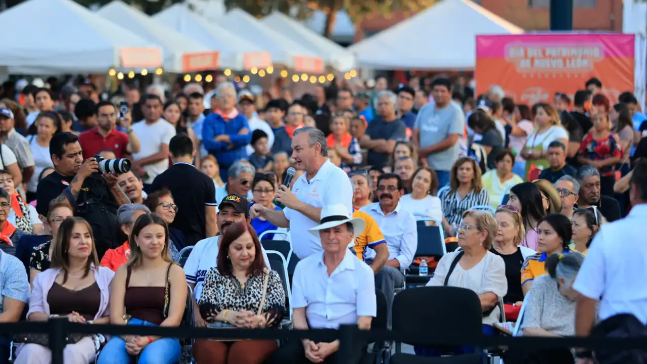 Personas adultas mayores disfrutando de un concierto al aire libre en una plaza pública