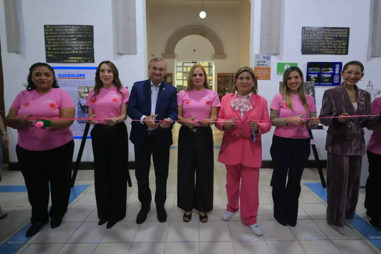 Mujeres observan fotografías en una exposición sobre cáncer de mama en un museo