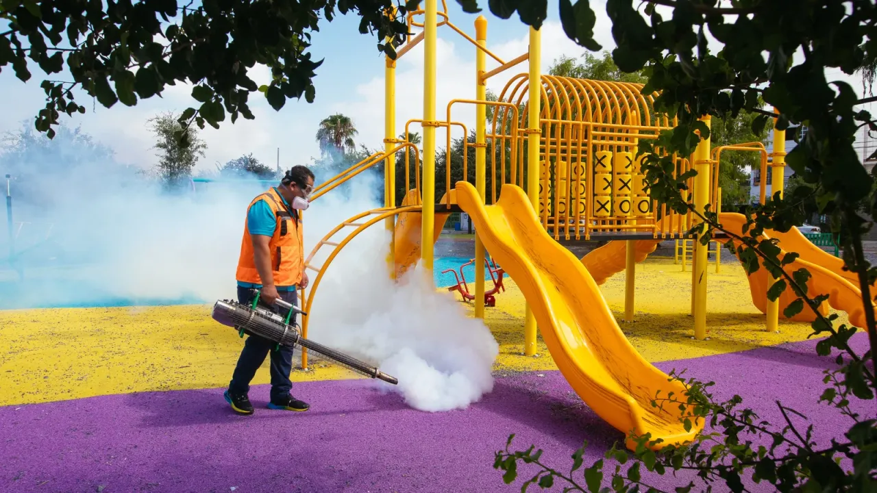 Personal de salud fumigando una calle en una colonia de Guadalupe