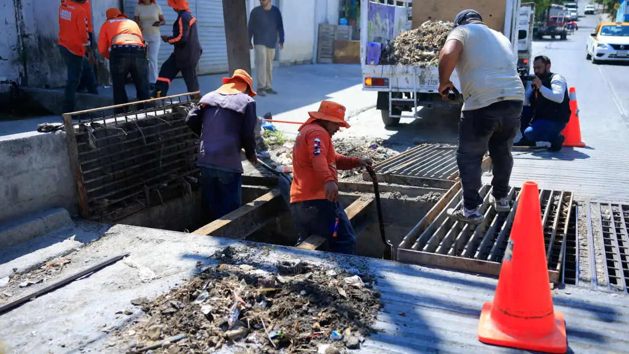 Trabajadores municipales limpiando una rejilla pluvial en una calle de Guadalupe