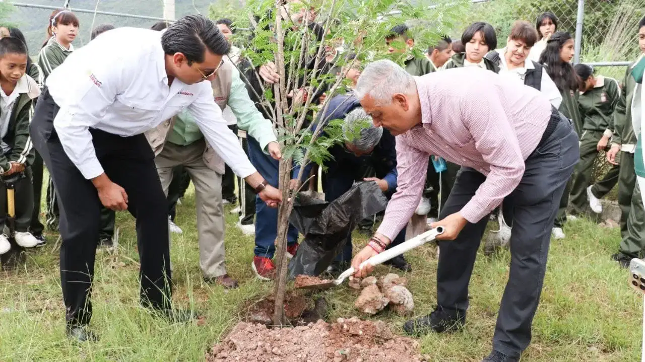 Estudiantes y autoridades plantando árboles en el patio de una escuela en Chilpancingo