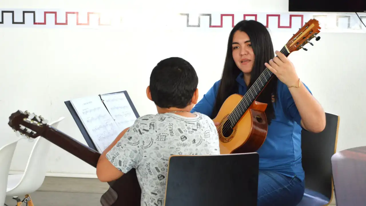Jóvenes con guitarras durante un ensayo musical