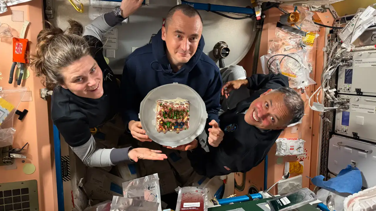 Tres tripulantes de la Expedición 74 posan con un pastel en la Estación Espacial Internacional