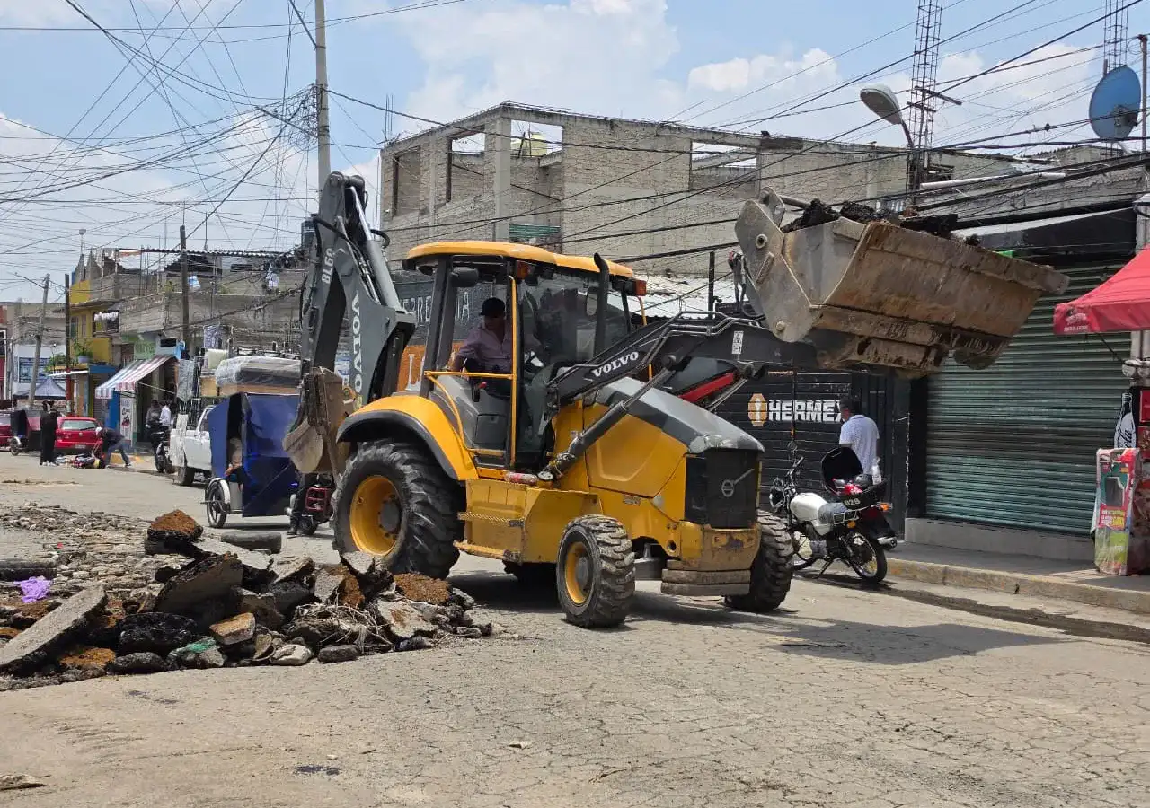 Maquinaria pesada retira escombros en una calle de Chimalhuacán después de lluvias