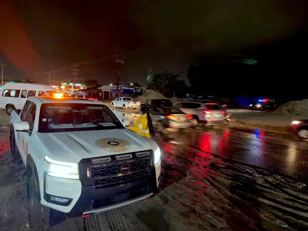 Vehículos circulando sobre pavimento mojado en una vialidad urbana de Los Cabos