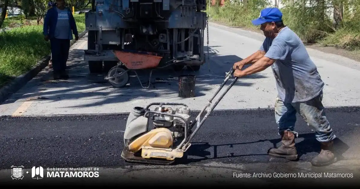 Trabajadores municipales realizan labores de mantenimiento vial en una avenida de Matamoros