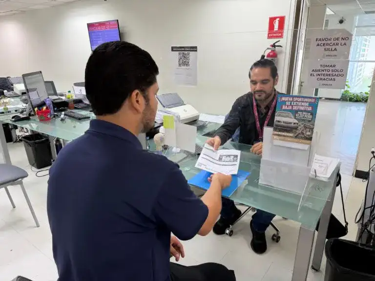 Fachada de una oficina de recaudación estatal con personas en la entrada