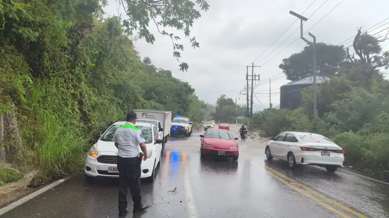Agente de tránsito dirige el tráfico en una calle con lluvia en Acapulco