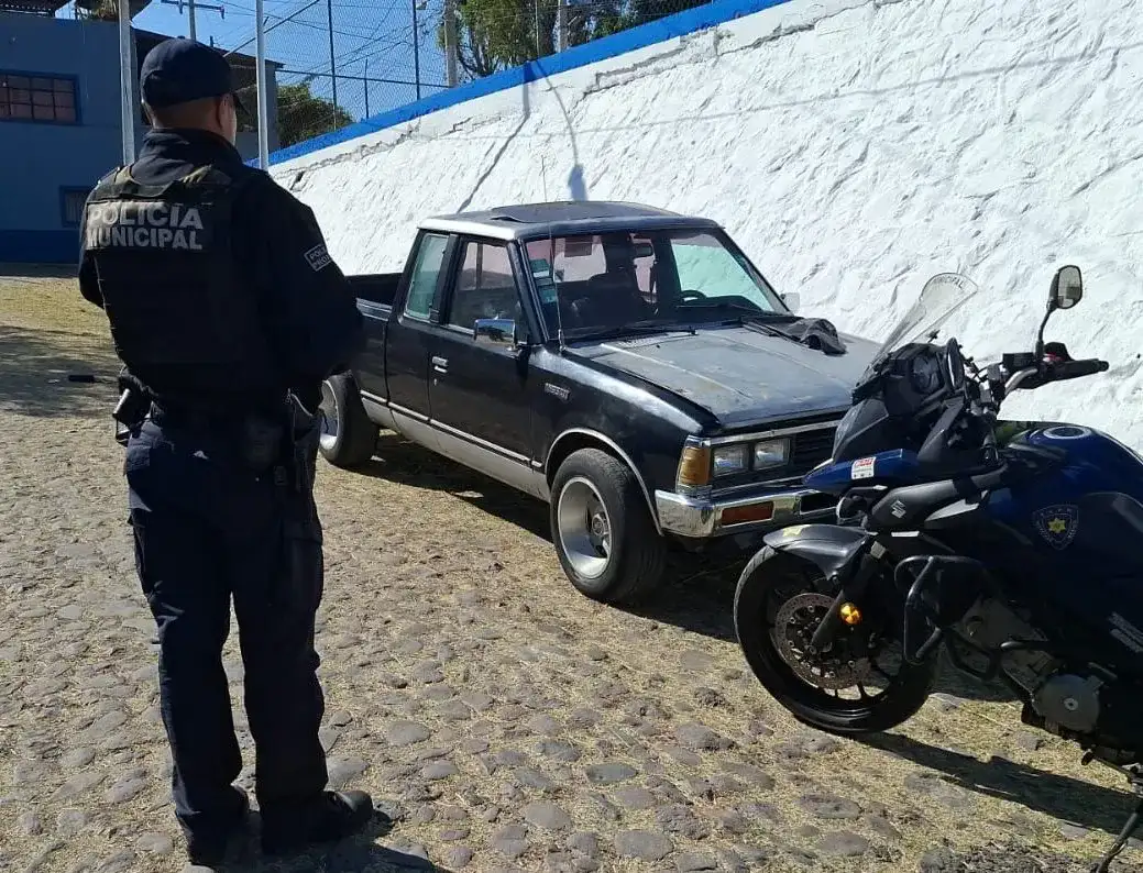 Agente de policía municipal de Querétaro revisa un vehículo recuperado