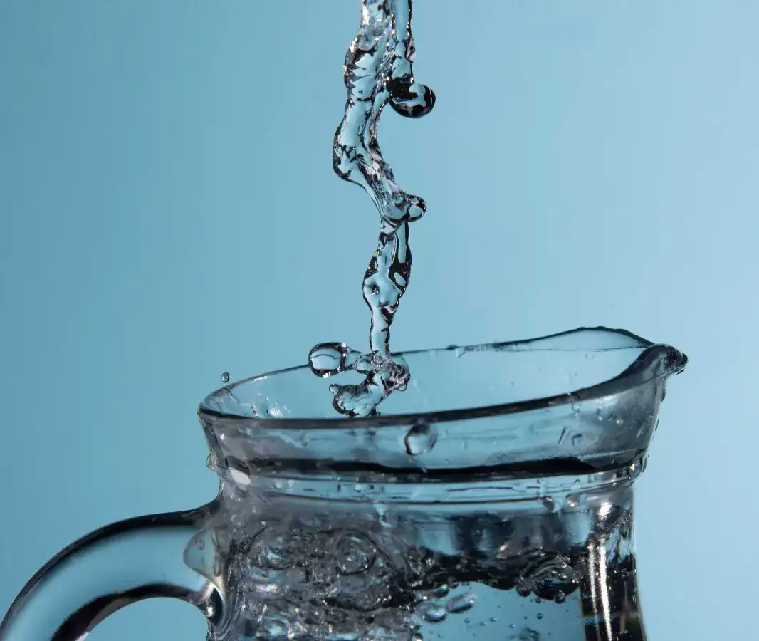 Personas llenando recipientes de plástico con agua en una comunidad rural