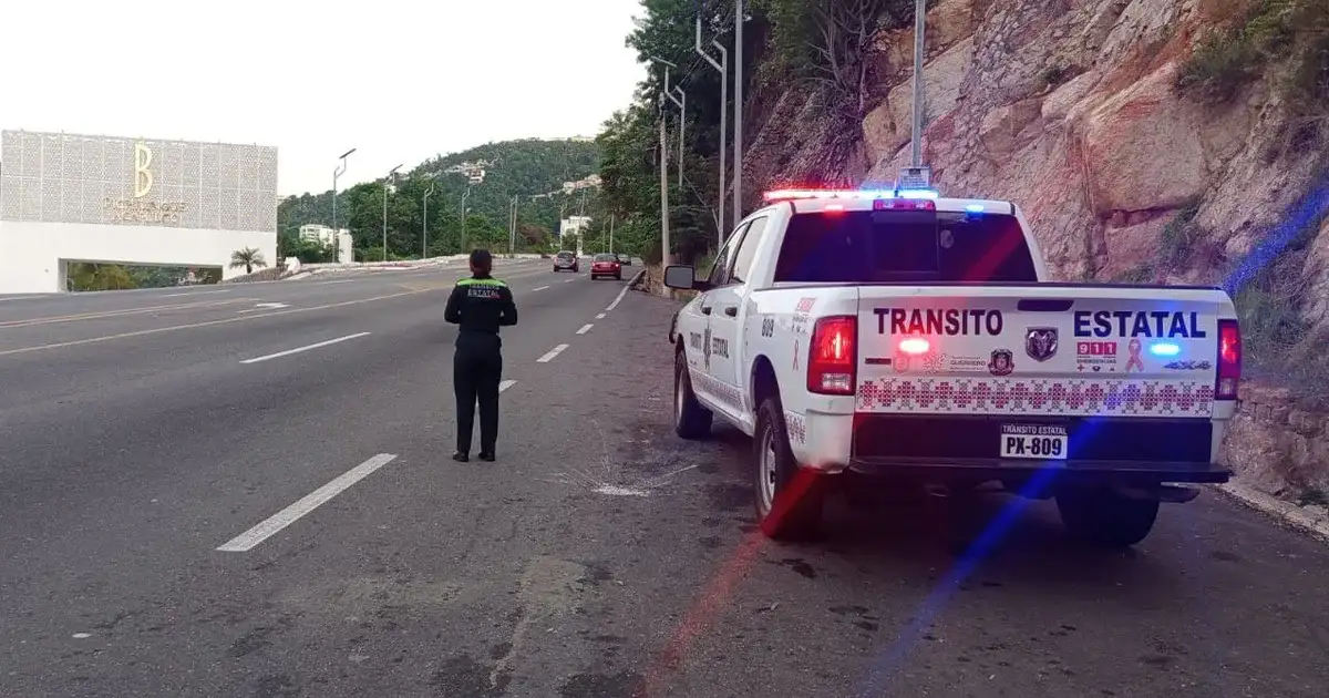 Agente de Tránsito Estatal en un mirador de la avenida Escénica de Acapulco orientando a un automovilista.