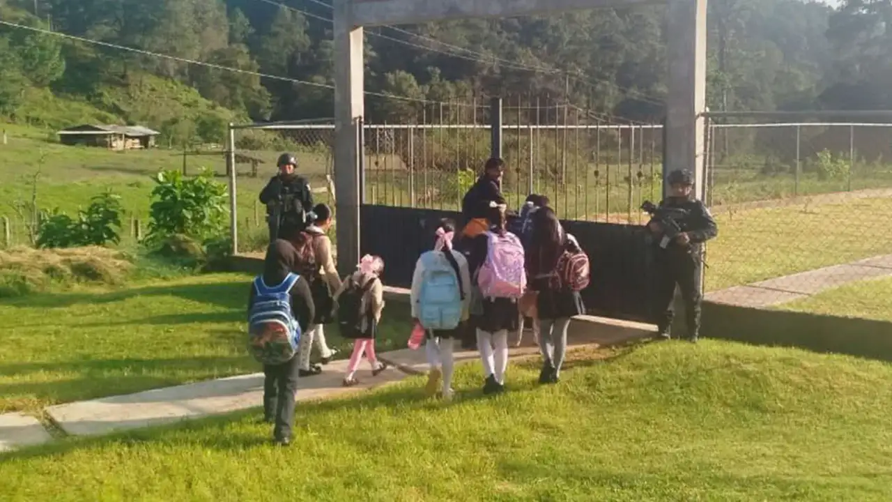 Elementos de la Policía Estatal realizan un patrullaje a pie frente a una escuela primaria en Fresnos de Puerto Rico, Guerrero.