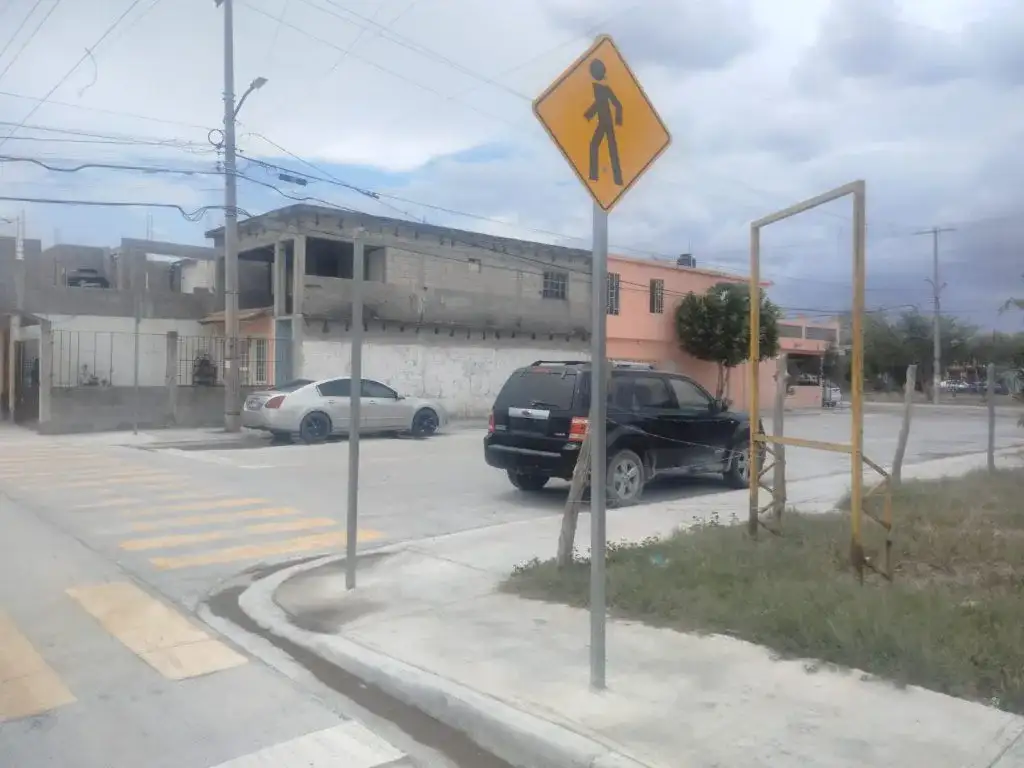 Operarios colocan un poste de señalización vial en una esquina de Reynosa
