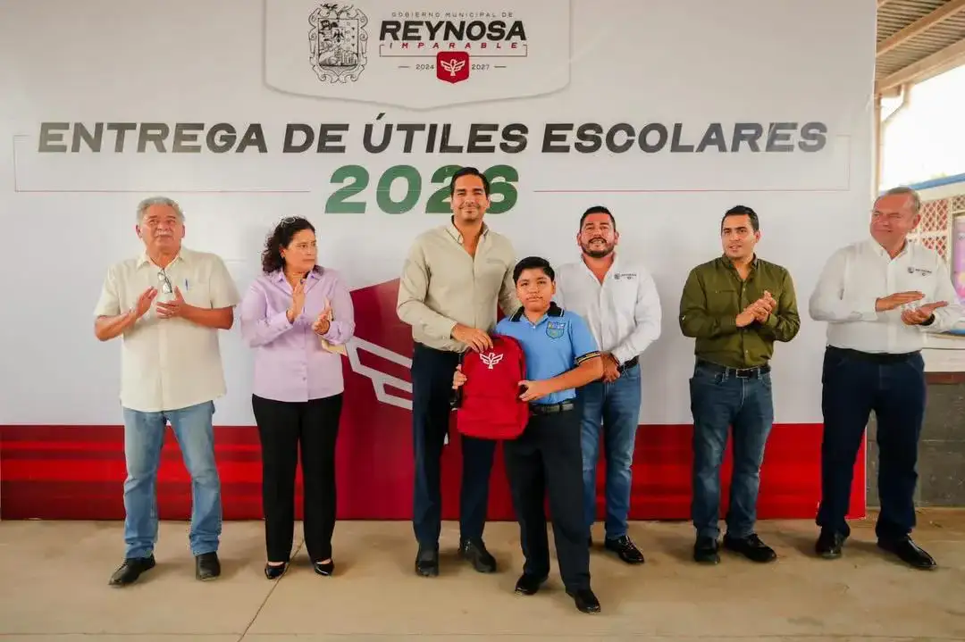 Estudiantes y autoridades durante la entrega de mochilas escolares en una primaria de Reynosa