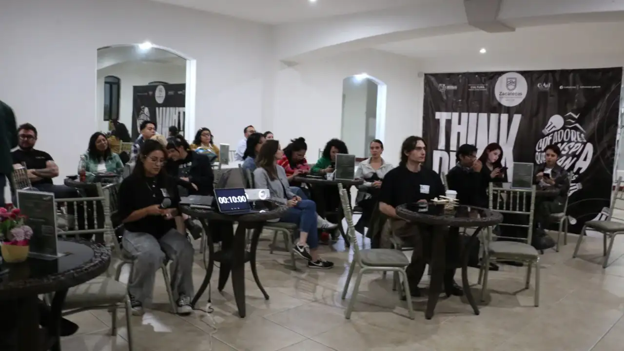 Personas conversando en un café durante un encuentro cultural en Zacatecas