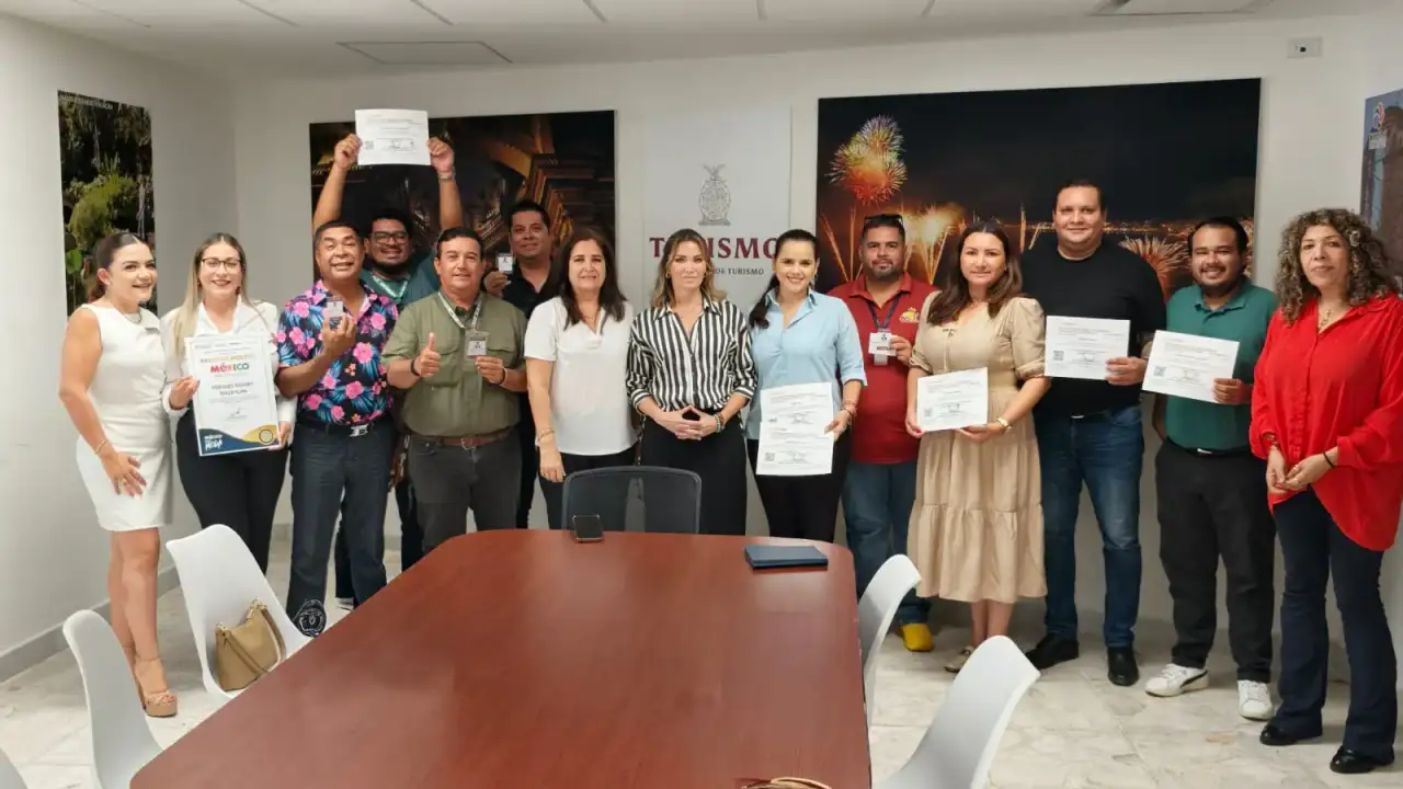 Funcionarios entregan reconocimiento a representante de hotel en evento de calidad turística en Mazatlán.