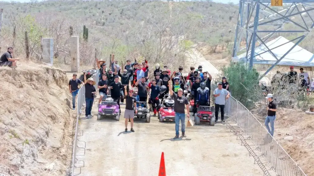 Personas descendiendo una colina en vehículos de juguete durante el evento Aventados 2.0 en Los Cabos