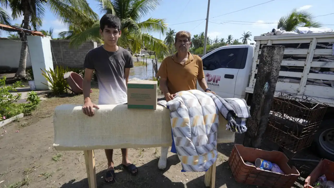 Familias y personal de protección civil en zona inundada de Sinaloa