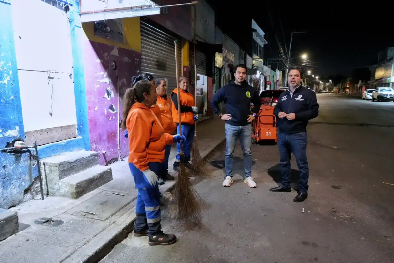 Trabajadores de limpieza recogen bolsas de basura en calles de Querétaro durante la madrugada
