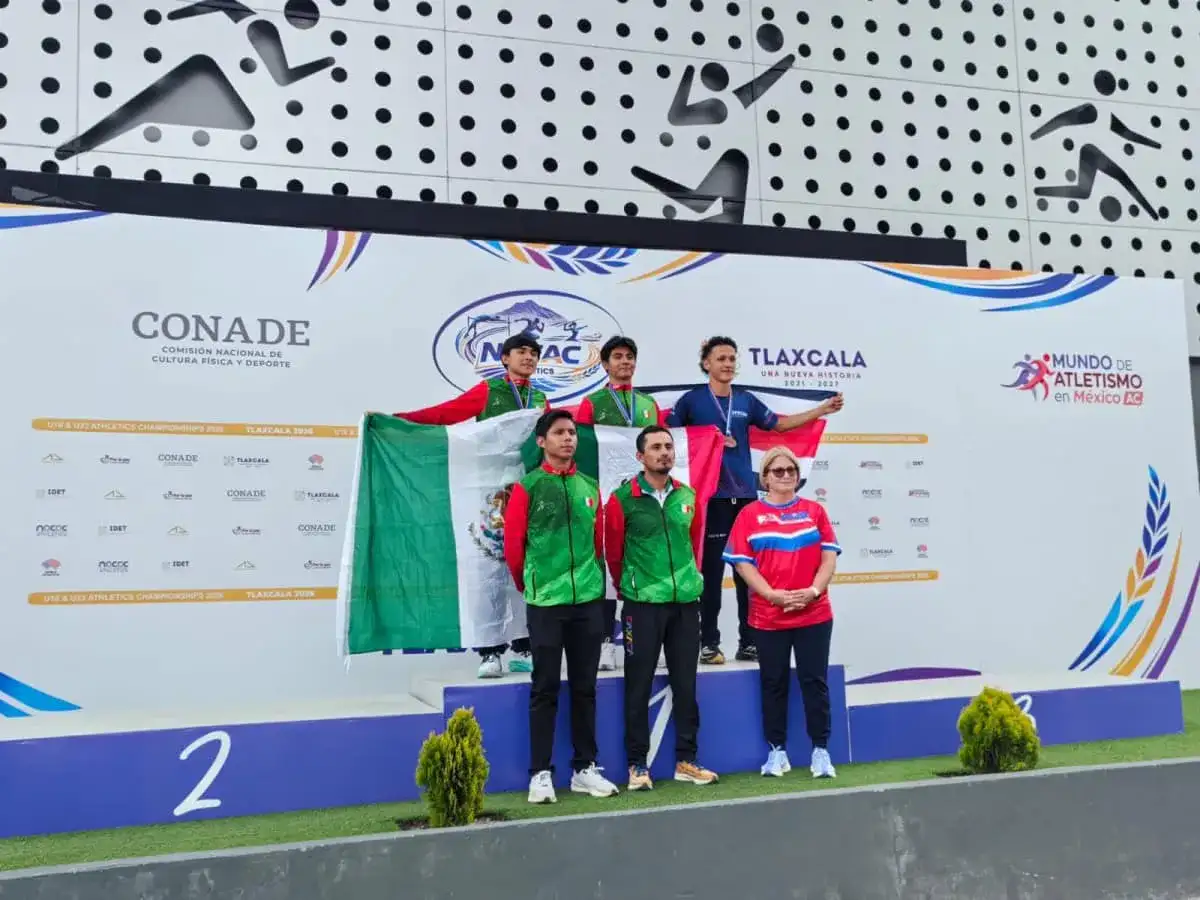 Atleta lanzando martillo en una pista de atletismo con público al fondo