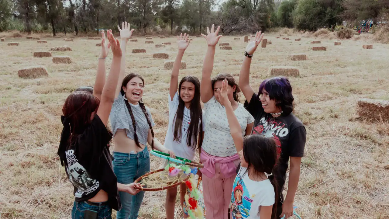Niñas y niños participan en una obra de teatro comunitario al aire libre