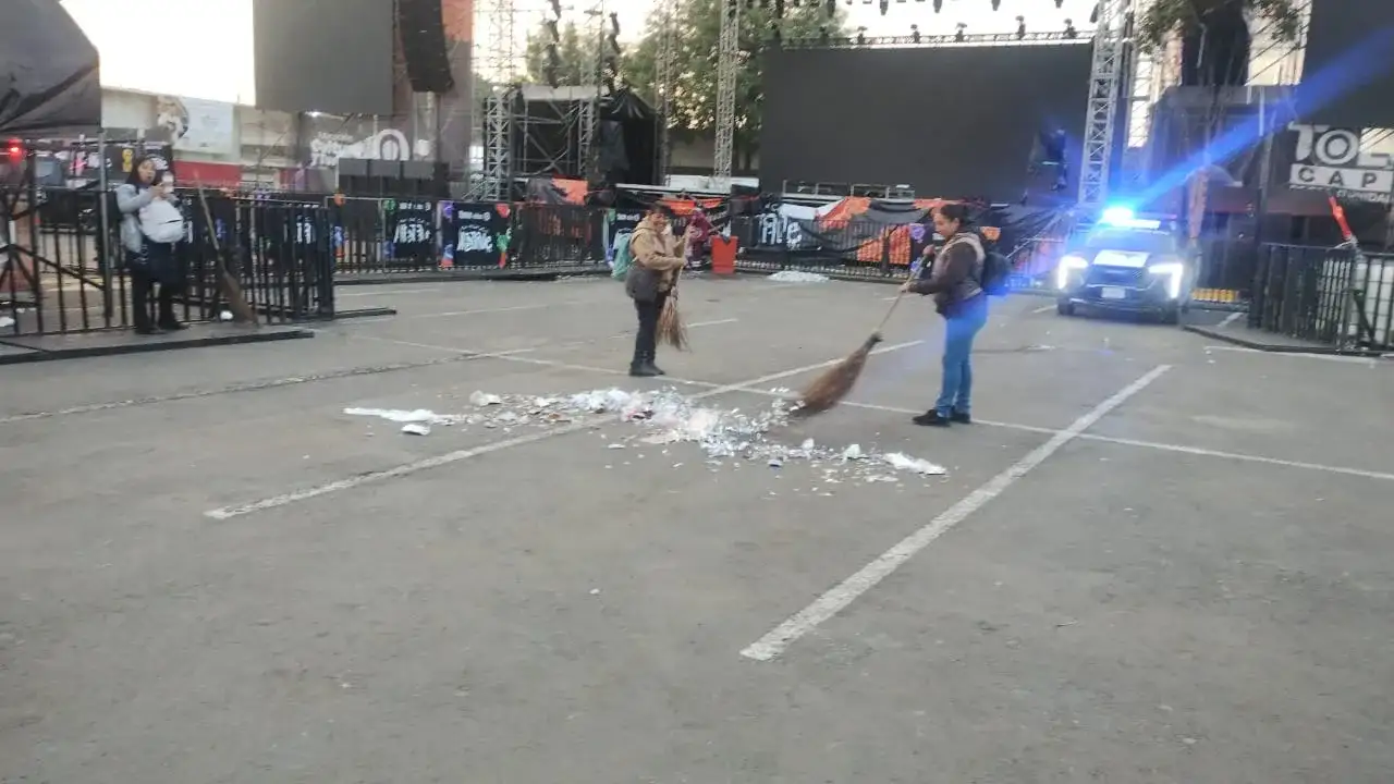 Trabajadores de limpieza barren la explanada del Mercado Juárez en Toluca