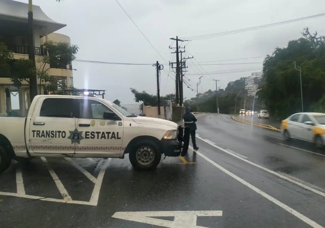 Vialidad de Acapulco con tránsito vehicular durante una lluvia