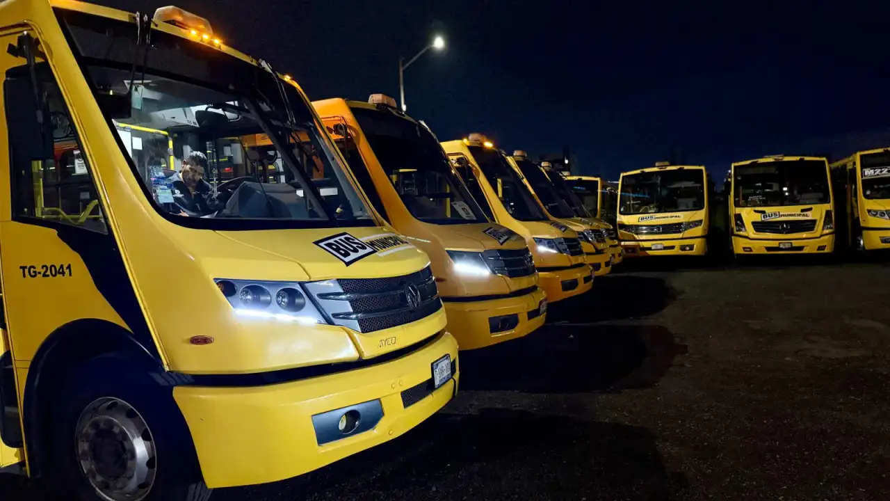 Unidades de transporte público nocturno en una avenida de Querétaro durante la noche