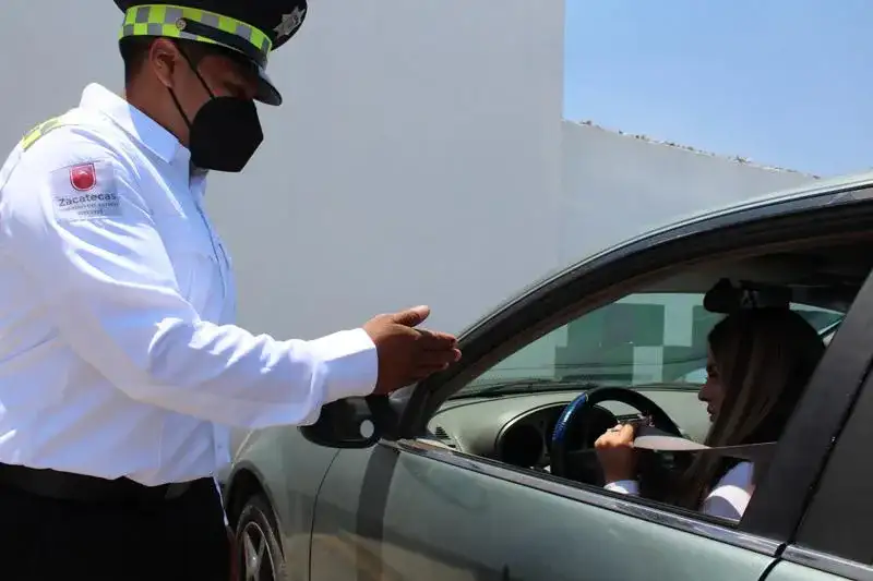 Oficial de tránsito revisando uso de cinturón en vehículo
