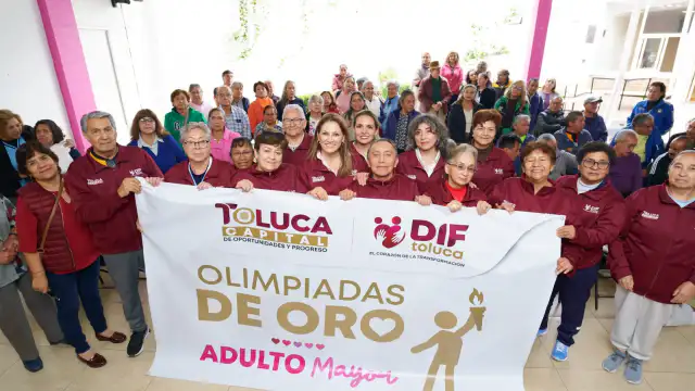 Adultos mayores con medallas y uniformes del DIF Toluca en una ceremonia de premiación