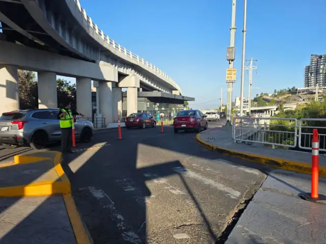 Personal vial y vehículos en un cruce con señalización temporal en Querétaro