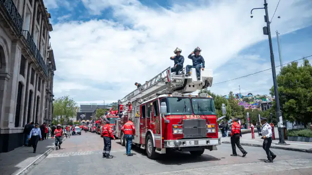 Caravana de bomberos con familias a bordo por calles de Toluca