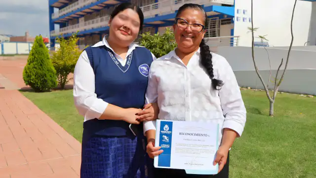 Madre e hija abrazándose en ceremonia de graduación de programa escolar en Guanajuato