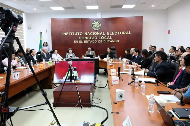 Personas formadas en una oficina del INE durante un trámite electoral