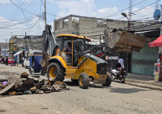 Maquinaria pesada retira escombros en una calle de Chimalhuacán después de lluvias