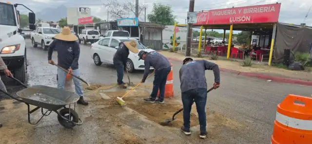 Cuadrilla de trabajadores realizando labores de bacheo en una vialidad urbana