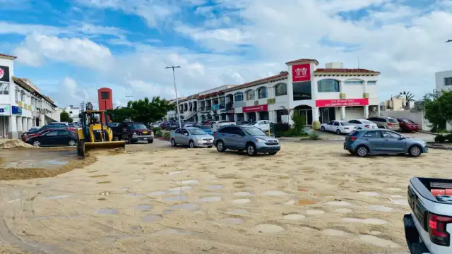 Trabajadores con maquinaria limpiando un canal pluvial en Los Cabos