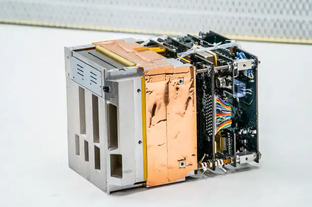 Ilustración del instrumento REAL montado en un CubeSat realizando mediciones de partículas energéticas.