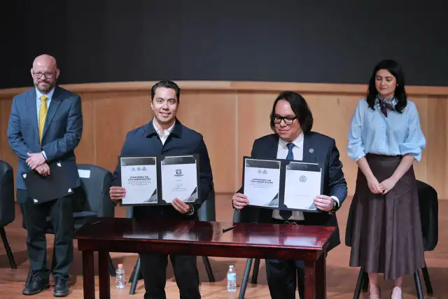 Autoridades durante la firma de un convenio en un auditorio de Querétaro